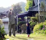 木の葉をかざして天を仰ぐ薫と見守る観音